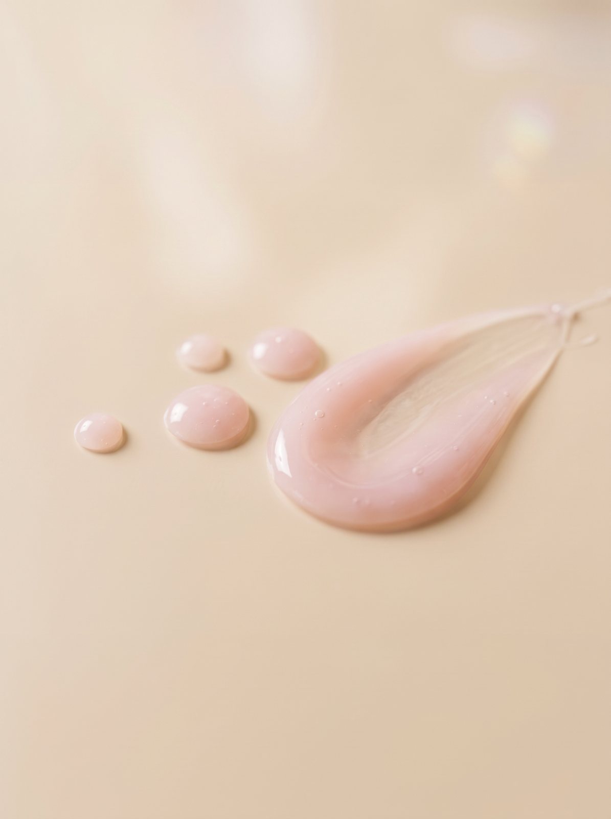 Drops of the soft blush-pink 5-in-1 serum